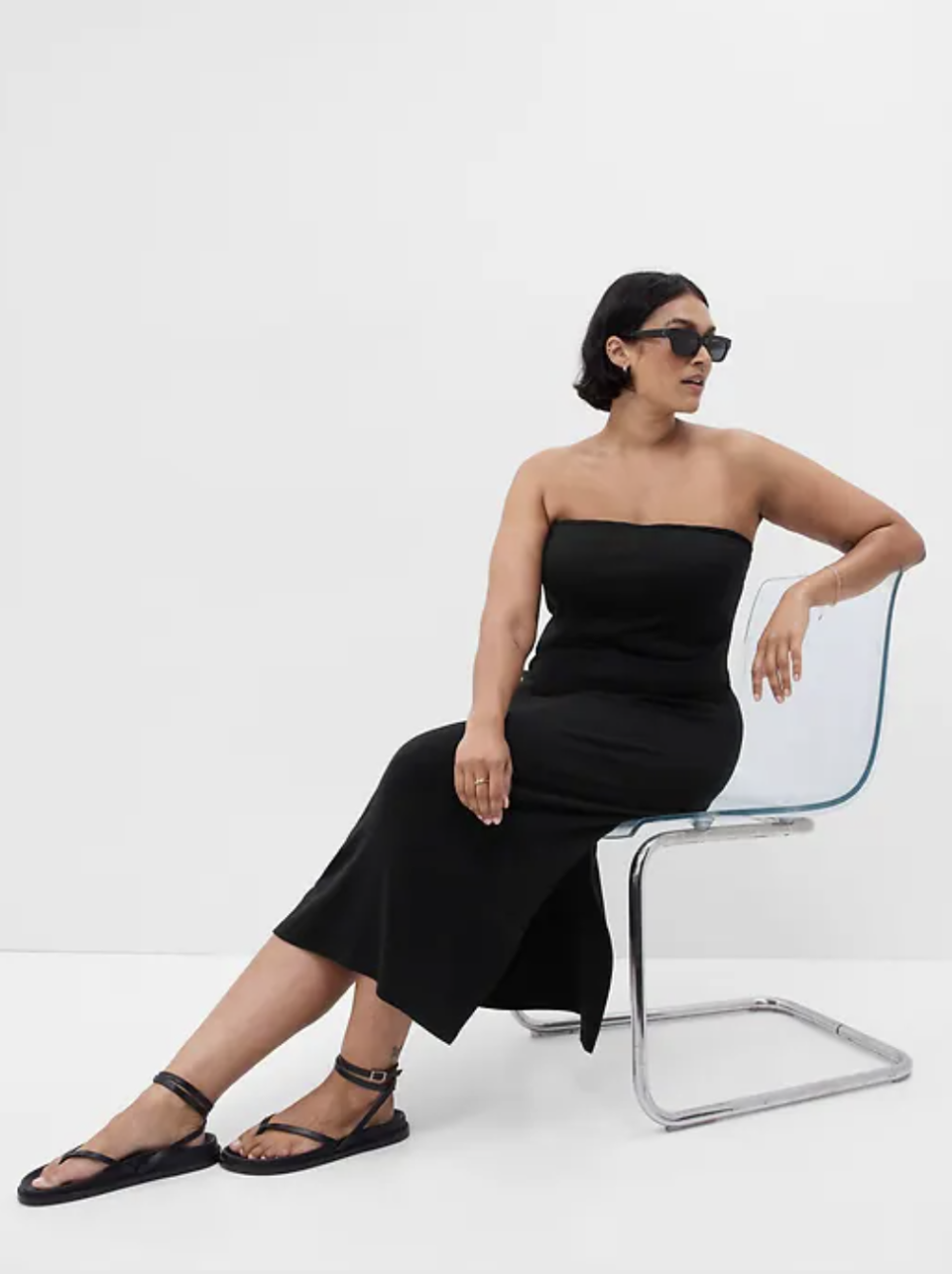 model sitting wearing black sandals and black strapless Modern Strapless Split-Hem Midi Dress (Photo via Gap)