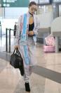 <p>Bella wears a Moschino tracksuit, black heeled boots, a black leather satchel and black top in the Milan airport. </p>