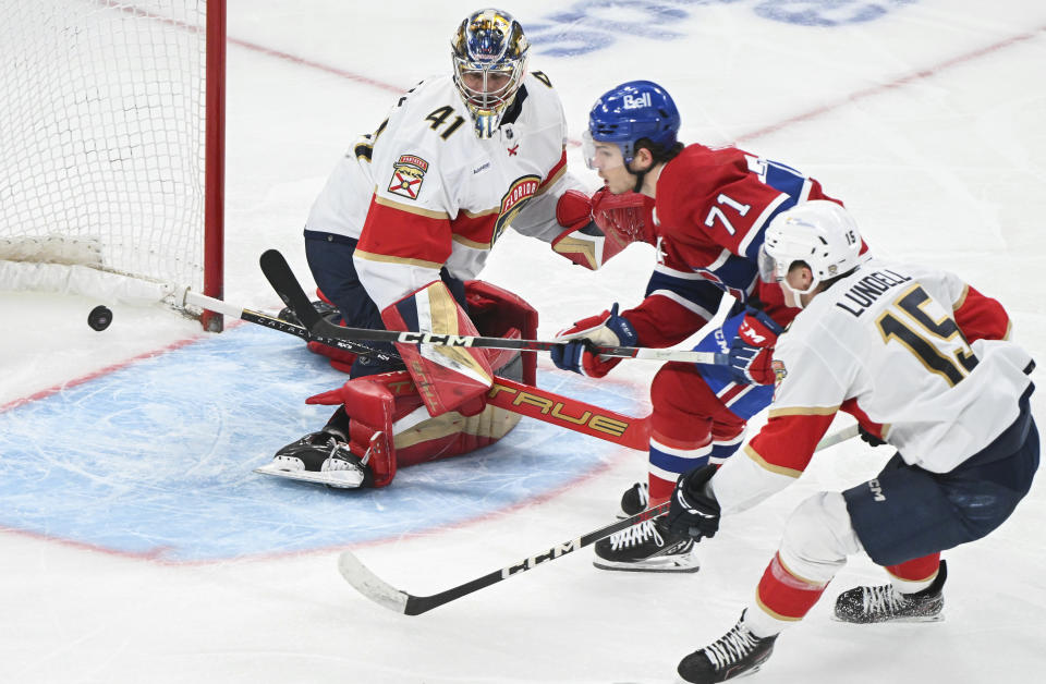 Montreal Canadiens' Jake Evans (71) scores against Florida Panthers goaltender Anthony Stolarz as Panthers' Anton Lundell (15) defends during the third period of an NHL hockey game Tuesday, April 2, 2024, in Montreal. (Graham Hughes/The Canadian Press via AP)