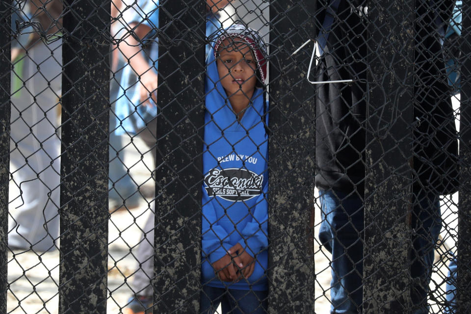 <p>A boy who is with a group of members of a migrant caravan from Central America and their supporters look through the U.S.-Mexico border wall at Border Field State Park before making an asylum request, in San Diego, California, April 29, 2018. (Photo: Lucy Nicholson/Reuters) </p>