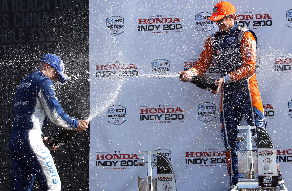 Scott Dixon, left, sprays teammate and second-place finisher Felix Rosenqvist after winning an IndyCar Series auto race, Sunday, July 28, 2019, at Mid-Ohio Sports Car Course in Lexington, Ohio. (AP Photo/Tom E. Puskar)