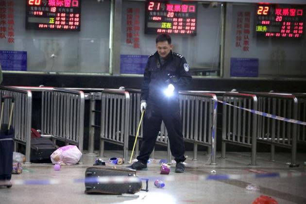 A police investigator inspects the scene of a mass stabbing at the railway station in Kunming, southwest China's Yunnan province, on March 2, 2014. (AFP photo)