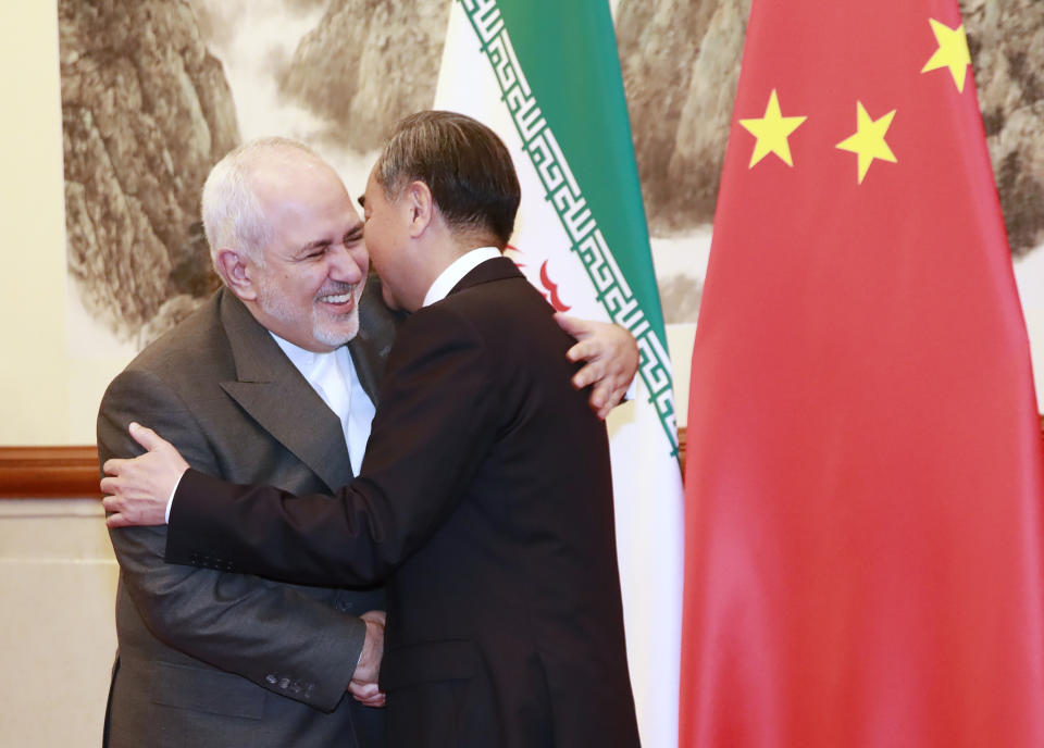 Chinese Foreign Minister Wang Yi, right, shakes hands with Iranian Foreign Minister Mohammad Javad Zarif at the Diaoyutai State Guesthouse in Beijing, Aug. 26, 2019. (How Hwee Young/Pool Photo via AP)