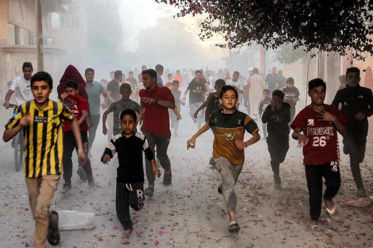 Niños palestinos corren mientras huyen de un bombardeo israelí en Rafah, en el sur de la Franja de Gaza (Archivo)