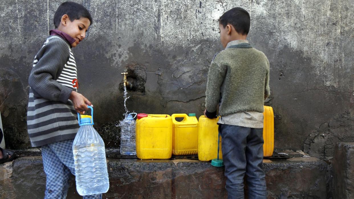 Zwei Jungen holen in Sanaa Wasser an einer Pumpe.