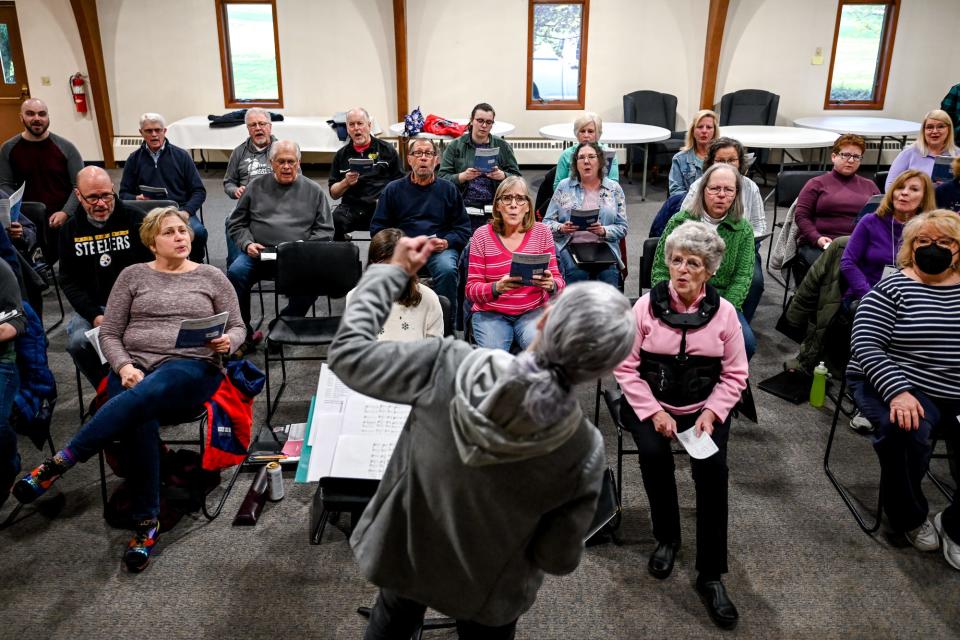 Delta Community Choir members sing as director Ellen McKenzie leads during a practice on Monday, April 24, 2023, at St. David's Episcopal Church in Lansing.