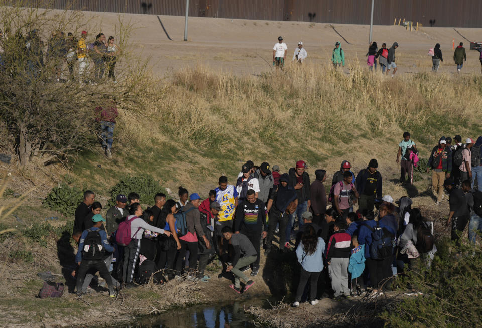 Migrants jump back and forth over the Rio Grande river into the United States and some back into Mexico, in Ciudad Juarez, Wednesday, March 29, 2023, a day after dozens of migrants died in a fire at a migrant detention center in Ciudad Juarez. (AP Photo/Fernando Llano)