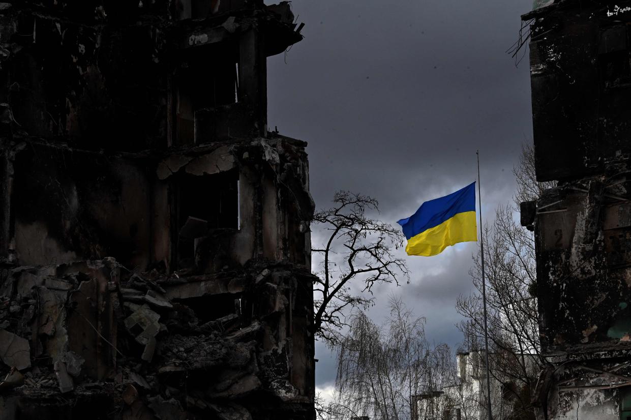 The Ukrainian flag flutters between buildings destroyed in bombardment, in the Ukrainian town of Borodianka, in the Kyiv region on April 17, 2022. 