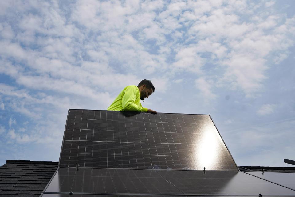 Nicholas Hartnett, owner of Pure Power Solar, places panel as his company installs a solar array on the roof of a home in Frankfort, Ky., Monday, July 17, 2023. Since passage of the Inflation Reduction Act, it has boosted the U.S. transition to renewable energy, accelerated green domestic manufacturing, and made it more affordable for consumers to make climate-friendly purchases, such as installing solar panels on their roofs. (AP Photo/Michael Conroy)