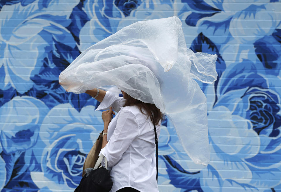 <p>A woman puts on a plastic cover before the 144th running of the Kentucky Derby horse race at Churchill Downs Saturday, May 5, 2018, in Louisville, Ky. (Photo: Jeff Roberson/AP) </p>