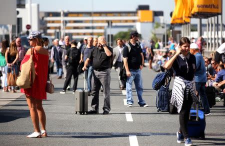 People gather outside Frankfurt airport terminal after Terminal 1 departure hall was evacuated in Frankfurt, Germany, August 31, 2016. REUTERS/Alex Kraus