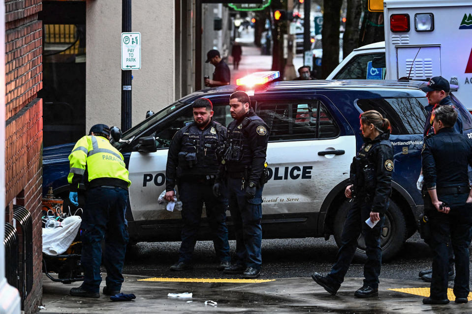 Portland Police officers watch American Medical Response paramedics transport a patient after they were administered Narcan  (Patrick T. Fallon / AFP via Getty Images file)
