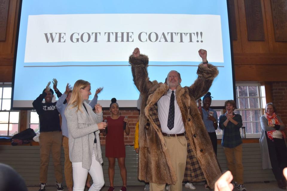 The raccoon coat is presented to St. Mark's Head of School, John Warren, at School Meeting in the fall of 2019 as students cheer along.