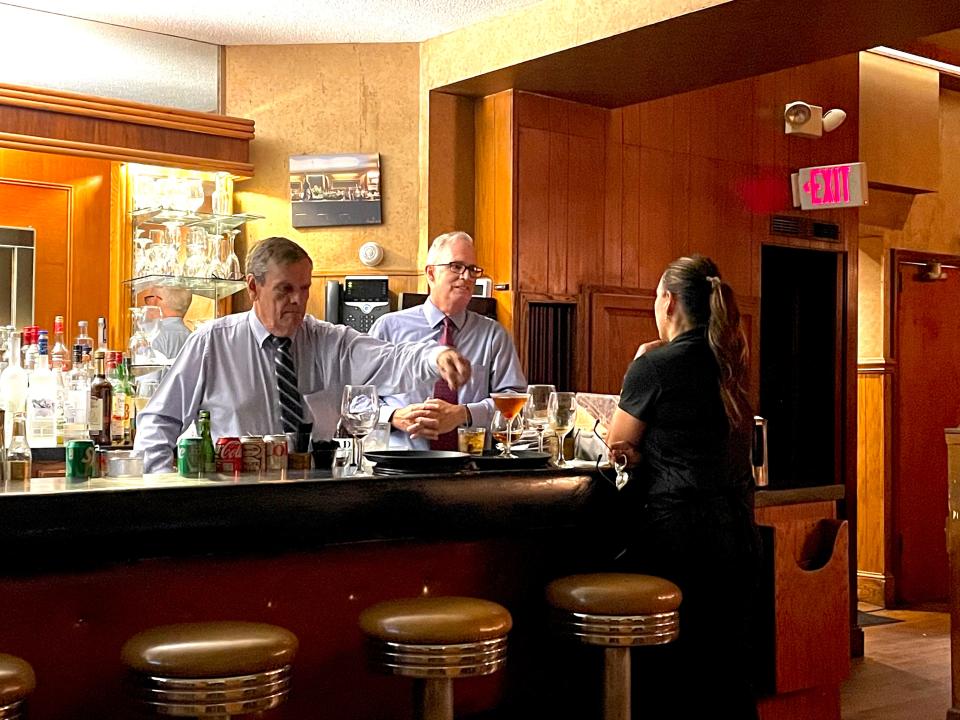 Bartenders Larry Thomas, left, and Scott Rigger chat with a worker at Akron's Diamond Grille.