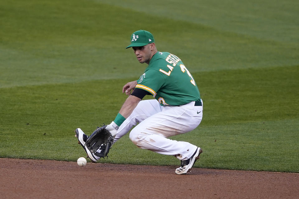 Oakland Athletics second baseman Tommy La Stella backhands a ground ball that was hit by San Diego Padres' Jake Cronenworth during the second inning of a baseball game in Oakland, Calif., Friday, Sept. 4, 2020. Cronenworth was out at first. (AP Photo/Tony Avelar)