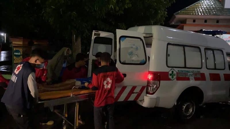 An injured person is being moved into an ambulance following an earthquake in Mamuju