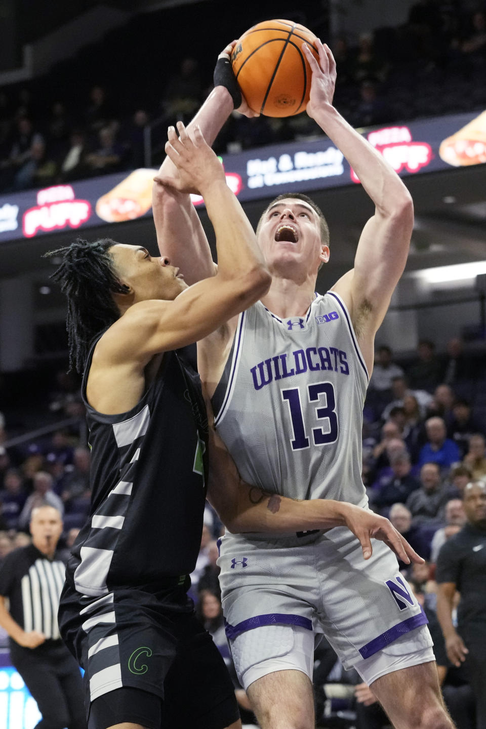 Northwestern guard Brooks Barnhizer (13) shoots against Chicago State forward Noble Crawford during the first half of an NCAA college basketball game in Evanston, Ill., Wednesday, Dec. 13, 2023. (AP Photo/Nam Y. Huh)