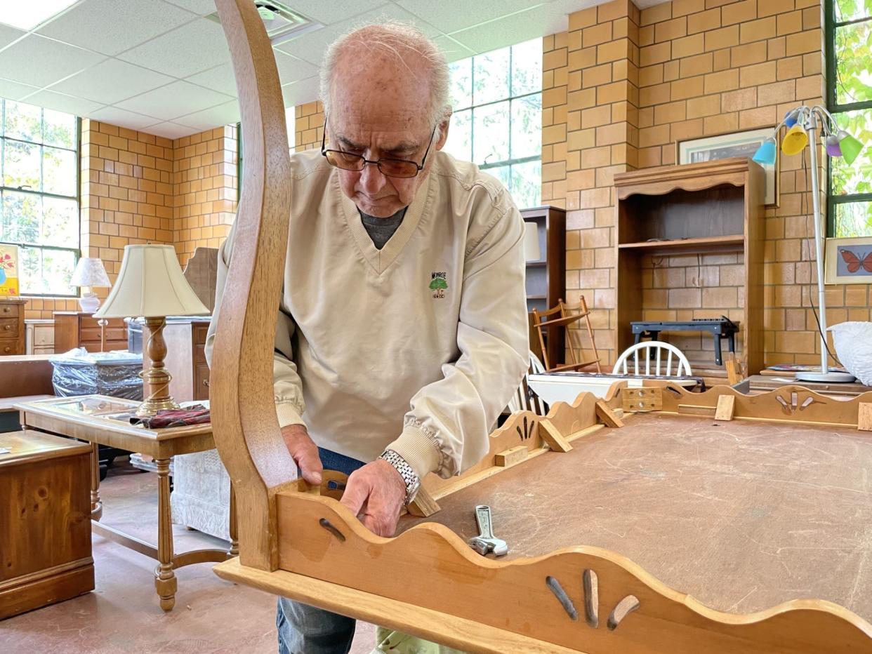 Longtime volunteer Bill Ziegler works on a wooden table. Ziegler completely refinished two of the donated wooden tables.
