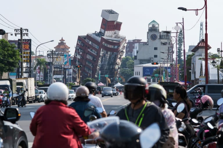 Residentes de la ciudad taiwanesa de Hualien transitan cerca de un edificio completamente inclinado por un terremoto, el 4 de abril de 2024 (Sam Yeh)