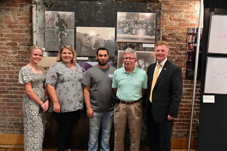 Centre College President Milton C. Moreland, right, with descendants of former Colonels football star Bo McMillin at the “C6H0” exhibit at Centre’s Combs Center Warehouse.