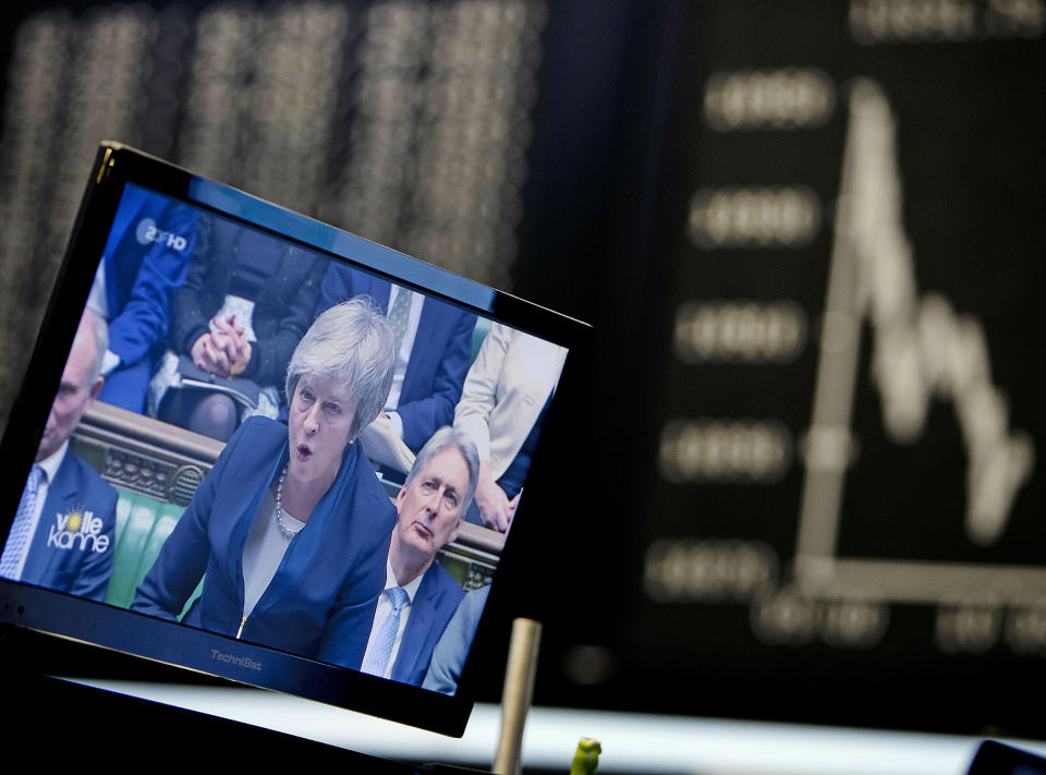 A computer screen shows news about the Brexit with Prime Minister Theresa May as the curve of the German stock index DAX is seen at the stock market in Frankfurt, Germany, Wednesday, Jan. 16, 2019. (AP Photo/Michael Probst)