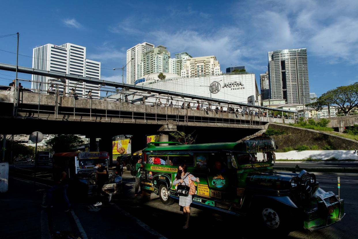 A passenger disembarks from a jeepney in Taguig City, Metro Manila, the Philippines, on March 22, 2022.The Philippines rate decision will be released March 24. Photographer: Geric Cruz/Bloomberg via Getty Images
