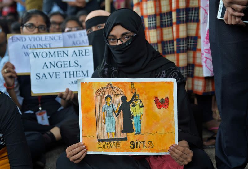People hold placards during a protest against the alleged rape and murder of a 27-year-old woman in Hyderabad