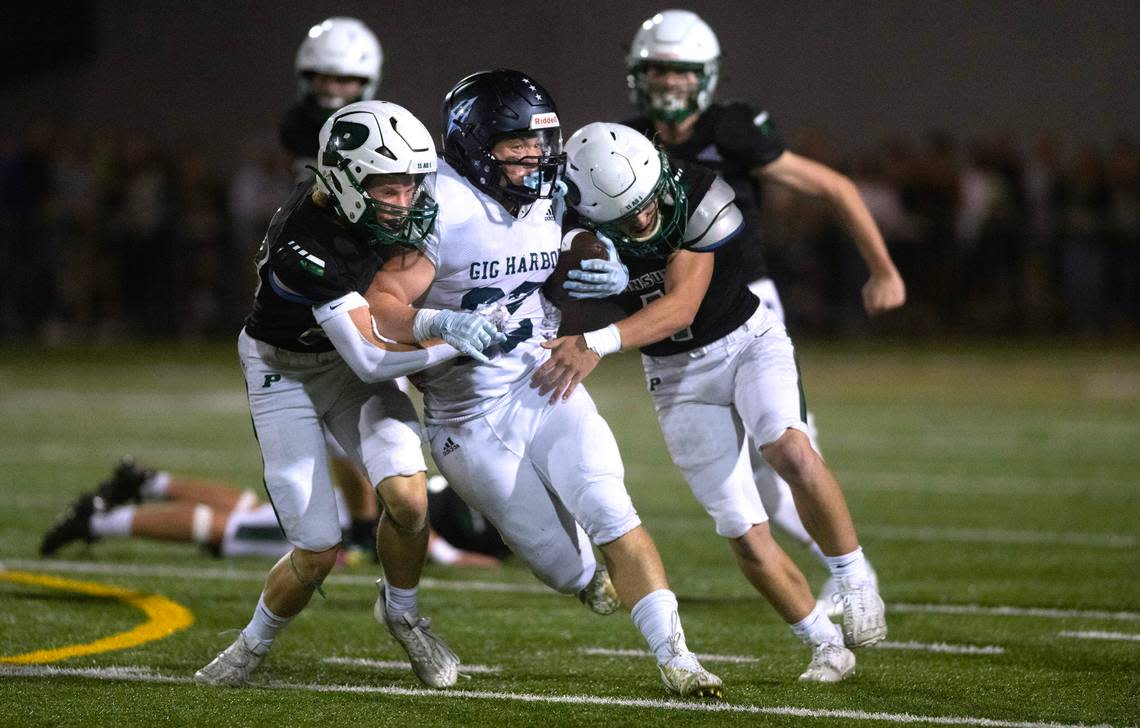 Gig Harbor running back Ryland Geldermann fights for yards between Peninsula defenders during Friday night’s Fish Bowl crosstown rivalry football game at Roy Anderson Field in Purdy, Washington, on Sept. 15, 2023. Gig Harbor won the game, 21-20.