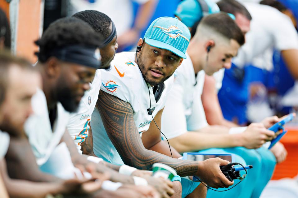 Tua Tagovailoa #1 of the Miami Dolphins talks to players on the bench during a preseason game against the Houston Texans at NRG Stadium on August 19, 2023 in Houston, Texas.