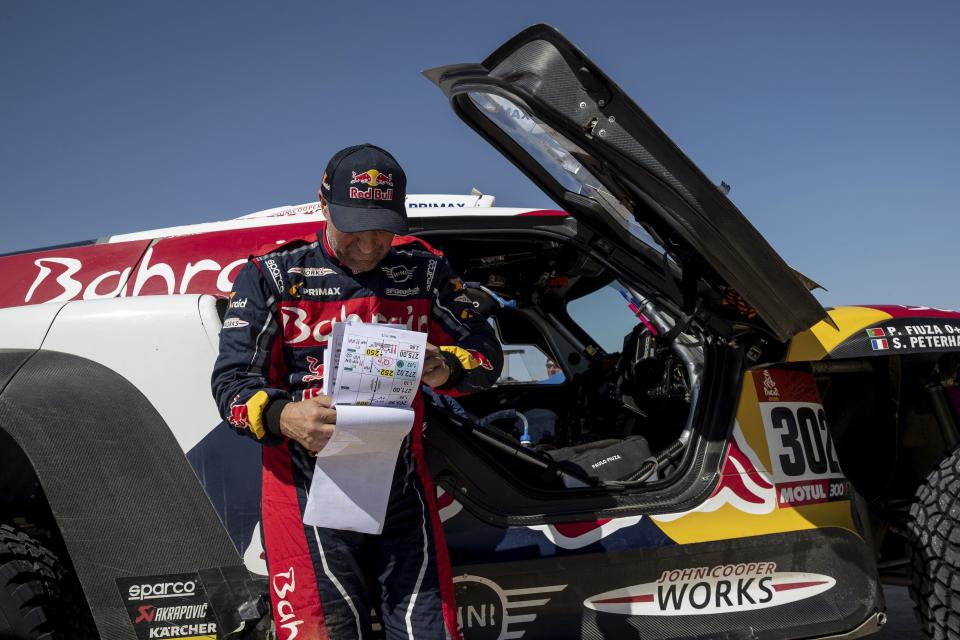 Driver Stephane Peterhansel, of France, checks the road book during stage eleven of the Dakar Rally between Shubaytah and Haradth, Saudi Arabia, Thursday, Jan. 16, 2020. (AP Photo/Bernat Armangue)