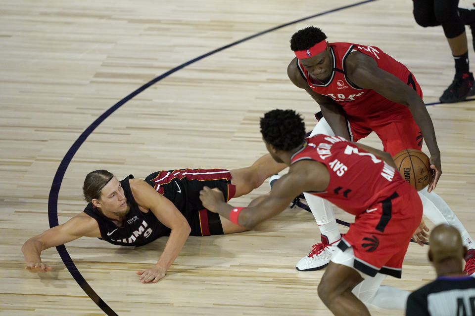 Miami Heat's Kelly Olynyk, left, loses the ball as Toronto Raptors' Pascal Siakam, right, picks it up during the second half of an NBA basketball game Monday, Aug. 3, 2020, in Lake Buena Vista, Fla. The Raptors won 107-103. (AP Photo/Ashley Landis, Pool)