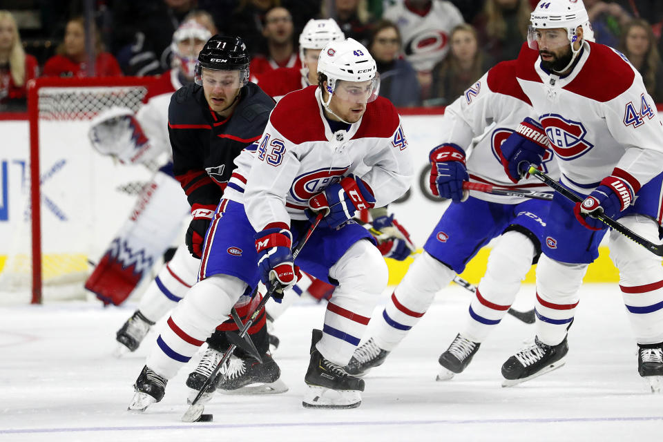 Montreal Canadiens' Jordan Weal (43) moves the puck away from Carolina Hurricanes' Lucas Wallmark (71), of Sweden, during the first period of an NHL hockey game in Raleigh, N.C., Tuesday, Dec. 31, 2019. (AP Photo/Karl B DeBlaker)