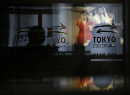 A visitor walks past logos at the Tokyo Stock Exchange in Tokyo June 13, 2013. REUTERS/Toru Hanai