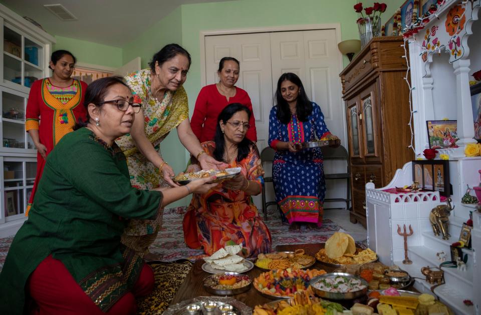 From left to right; Janki Patel, Niharika Patel, Chandan Patel, Lata Patel, Panna Patel and Viraj Patel, organize multiple dishes in front of an alter to celebrate Annakut, on one of the Diwali Days that the Patel family celebrate for Diwali in Sterling Heights on Tuesday, Oct. 25, 2022. 