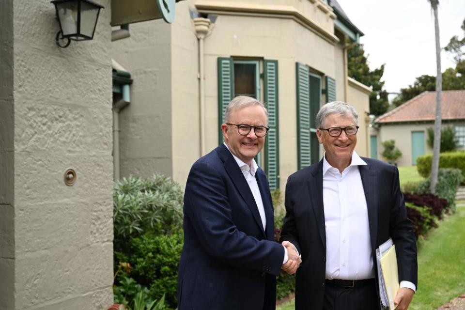 Australian PM Anthony Albanese and Bill Gates wearing suits shake hands outside a building.