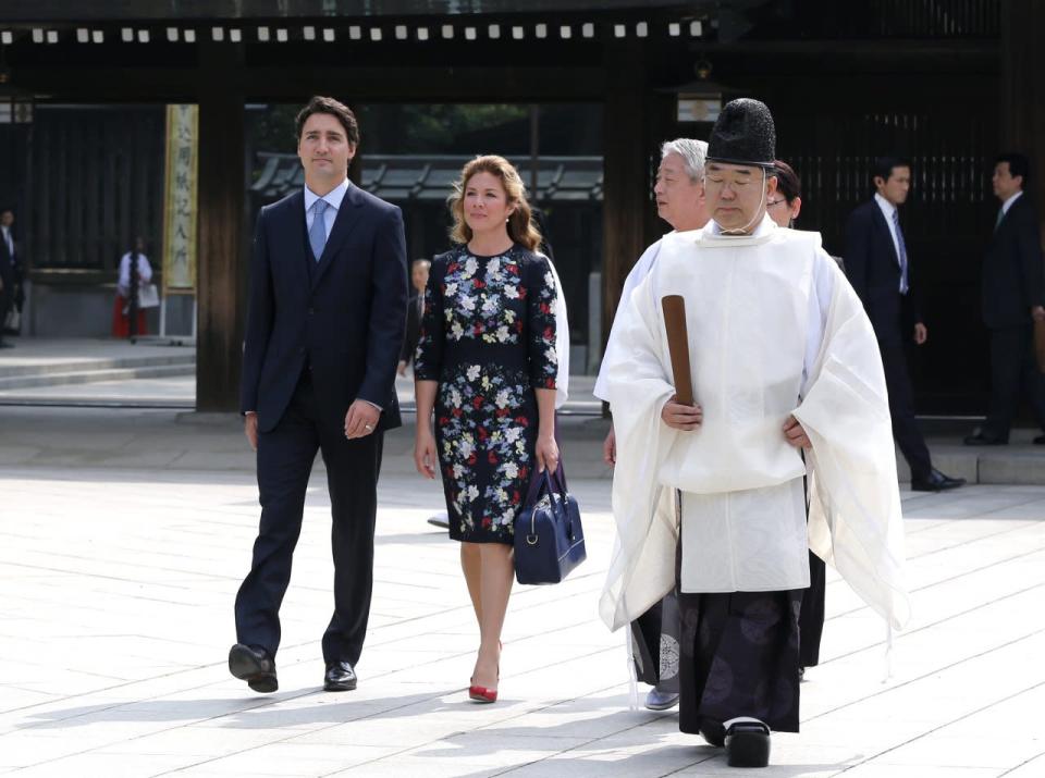 Canadian Prime Minister Justin Trudeau, left, and wife Sophie Gregoire Trudeau, second left, visit the Meiji Shrine, escorted by a shinto priest in Tokyo, Japan, on Tuesday, May 24, 2016. (AP Photo/Shuji Kajiyama)