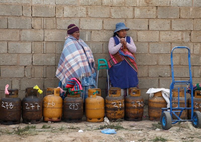 Women line up with gas canisters next to blocked petrol plant of Senkata in El Alto outskirts of La Paz