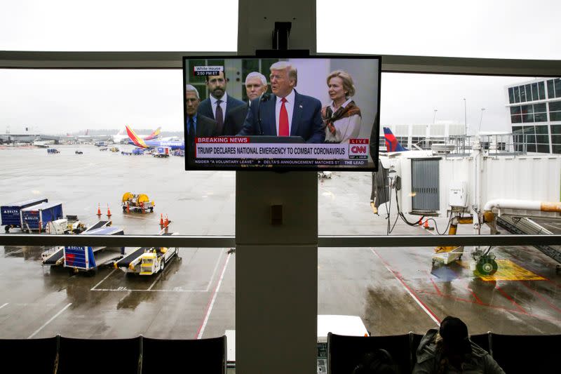 FILE PHOTO: U.S. President Donald Trump is pictured on a television at Seattle-Tacoma International Airport as he declares a national emergency over the coronavirus, in SeaTac Washington