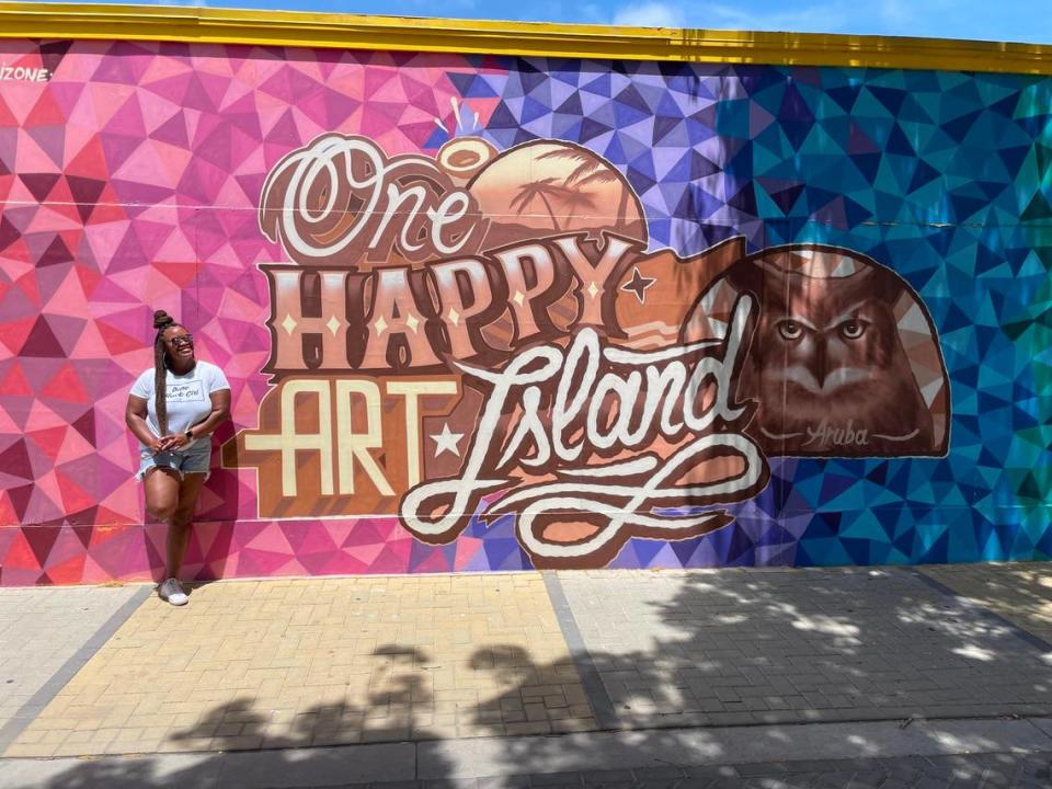CharlotteFive’s DeAnna Taylor poses with murals in San Nicolas, Aruba.