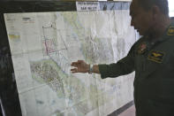 Lt. Col Bambang Sudewo, commander of the 5th Air Squadron "Black Mermaids" examines a map following a search operation for the missing Malaysia Airlines Boeing 777 that was conducted over the Strait of Malacca, at Suwondo air base in Medan, North Sumatra, Indonesia, Friday, March 14, 2014. The jetliner vanished nearly a week ago with 239 people aboard. (AP Photo/Binsar Bakkara)