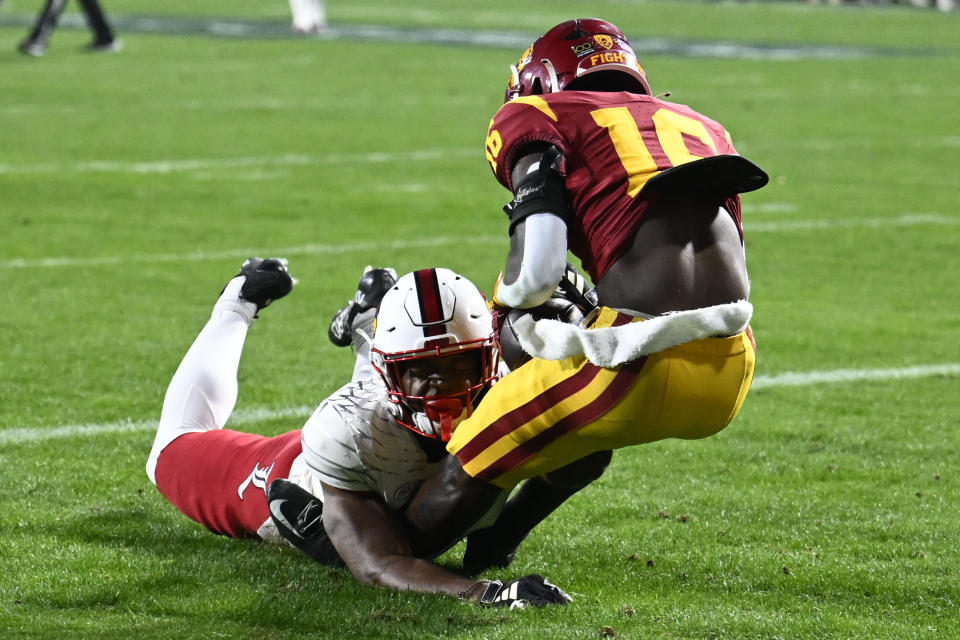Southern California wide receiver Tahj Washington (16) makes a touchdown catch in front of Louisville defensive back Storm Duck (29) during the first half of the Holiday Bowl NCAA college football game Wednesday, Dec. 27, 2023, in San Diego. (AP Photo/Denis Poroy)