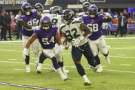 Seattle Seahawks running back Chris Carson (32) runs for a touchdown in front of Minnesota Vikings middle linebacker Eric Kendricks (54) and defensive tackle Michael Pierce (58) in the first half of an NFL football game in Minneapolis, Sunday, Sept. 26, 2021. (AP Photo/Jim Mone)