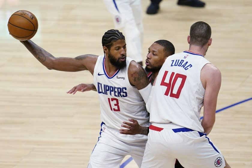 Los Angeles Clippers guard Paul George (13) holds the ball as Ivica Zubac (40) sets a screen on Portland Trail Blazers guard Damian Lillard, center, during the second half of an NBA basketball game Tuesday, April 6, 2021, in Los Angeles. (AP Photo/Marcio Jose Sanchez)