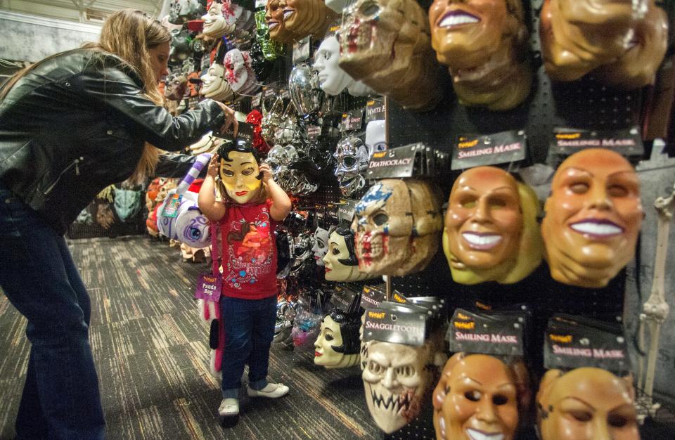 MATT DAYHOFF/JOURNAL STAR Sarah Watkins of Washburn helps her daughter Violet, 3, try on a Halloween mask on Monday, Oct. 30, 2017, at the Spirit Halloween store at 105 N. Main Street in East Peoria.