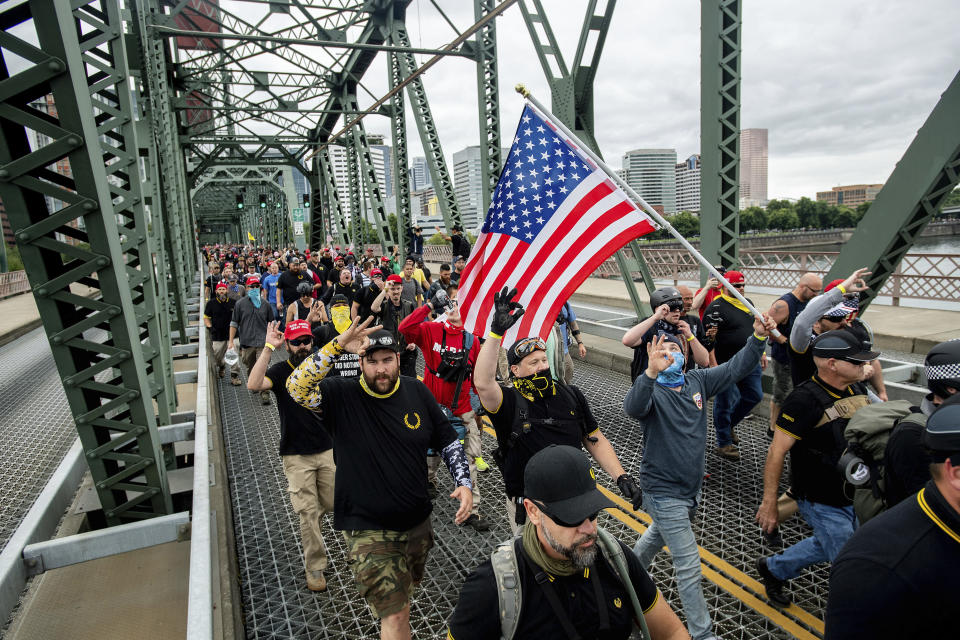 Members of the Proud Boys and other right-wing demonstrators march across the Hawthorne Bridge during an &quot;End Domestic Terrorism&quot; rally in Portland, Ore., on Saturday, Aug. 17, 2019. Police have mobilized to prevent clashes between conservative groups and counter-protesters who converged on the city. (AP Photo/Noah Berger)