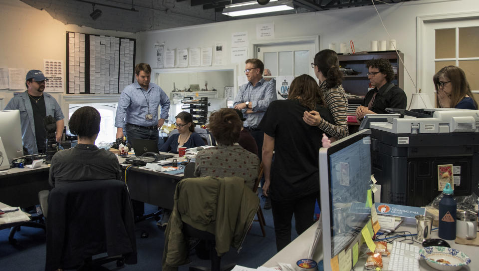 Editor Rick Hutzell, center, gives a speech to his staff at the Capital Gazette in Annapolis, Md., Monday, April 15, 2019. Hutzell said Monday that his staff experienced some "rollercoaster moments" as it won a special Pulitzer Prize citation for its coverage and courage in the face of a massacre in its own newsroom. "Clearly, there were a lot of mixed feelings," Hutzell told The Associated Press. "No one wants to win an award for something that kills five of your friends." (Ulysses Muoz/The Baltimore Sun via AP)