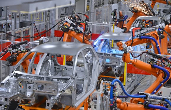 Robotic arms assembling cars in a factory