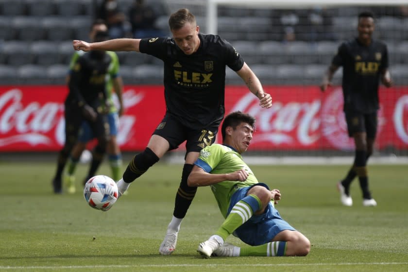 Los Angeles FC midfielder Corey Baird (13) and Seattle Sounders midfielder Josh Atencio (84) vie for the ball during the first half of an MLS soccer match, Saturday, April 24, 2021, in Los Angeles. (AP Photo/Ringo H.W. Chiu)