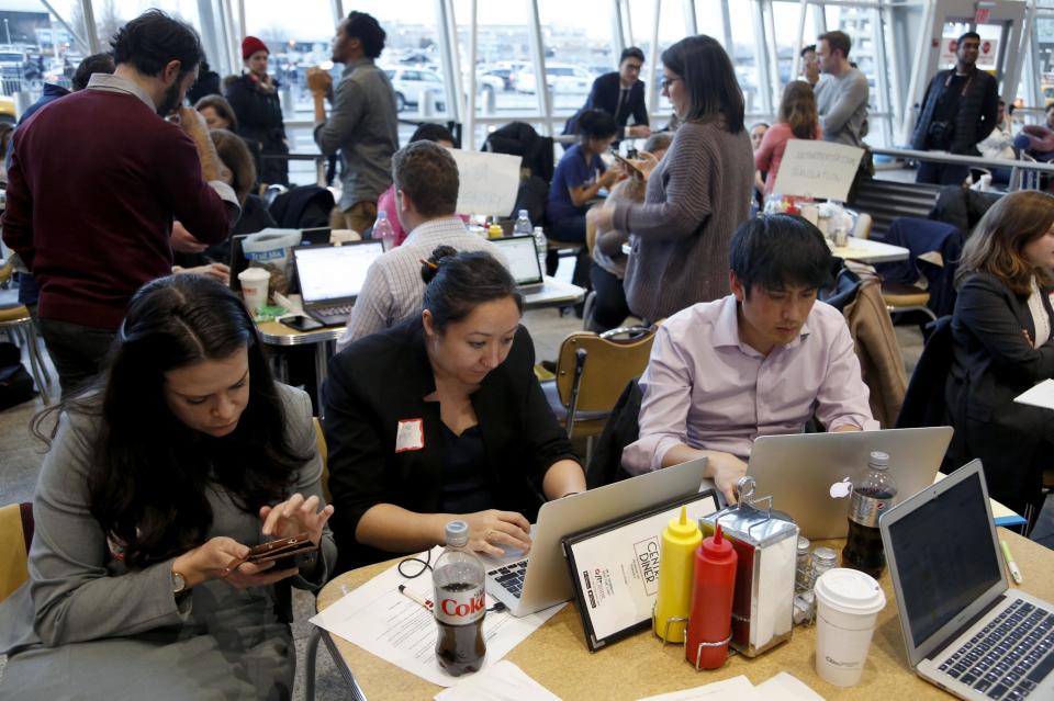 FILE - In this Sunday, Jan. 29, 2017, file photo, volunteer lawyers work to help free travelers detained at John F. Kennedy International Airport in New York. A cadre of volunteer lawyers, translators and others camped out in a diner at John F. Kennedy Airport, trying to find and free people abruptly detained under President Donald Trump's order temporary banning refugees and citizens from seven Muslim-majority countries from traveling to the U.S. (AP Photo/Seth Wenig, File)