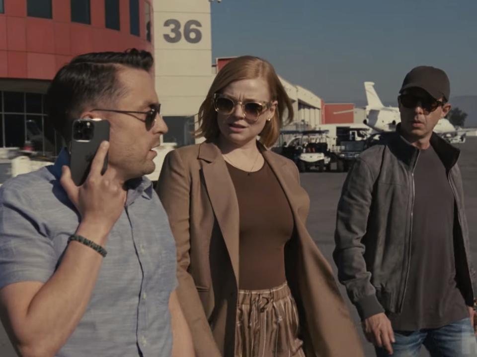 Roman, Shiv, and Kendall Roy walk across an airfield wearing sunglasses in this still from the trailer for season four of "Succession."